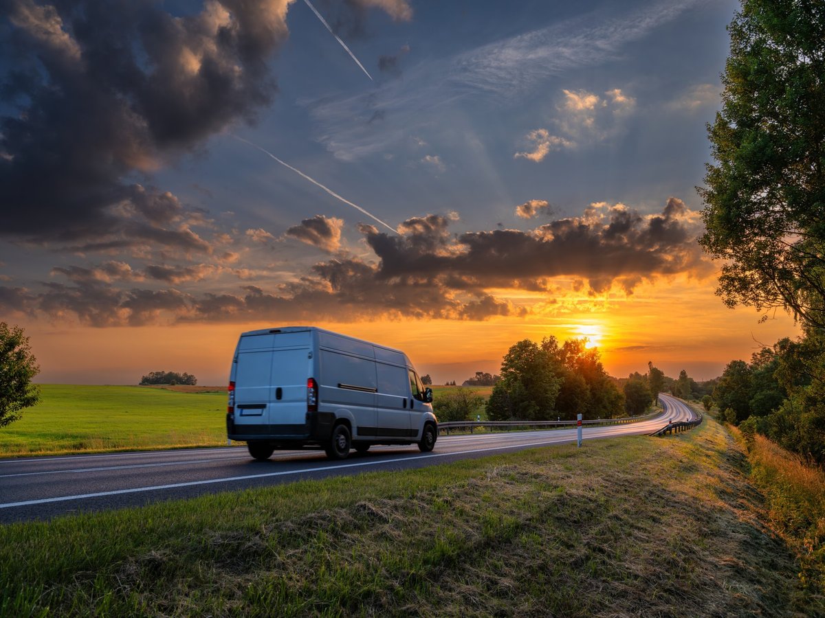 Delivery van on the road at sunset